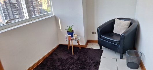 Sillón de la consulta junto a la ventana con vista a la ciudad
